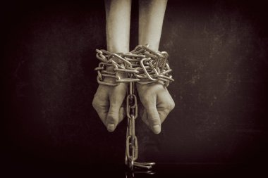 Kat zincirleme metal zincirler yakın çekim retro film izlemeye tonda siyah bir arka plan üzerinde beyaz kadınların el vardır