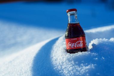 Kazan, Rusya, Mart, 17, 2018: Özgün cam şişe Coca-Cola donmuş karda parlak gün batımı sıkışmış