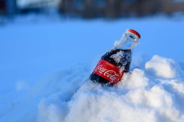 Kazan, Rusya, Mart, 17, 2018: Özgün cam şişe Coca-Cola donmuş karda parlak gün batımı sıkışmış