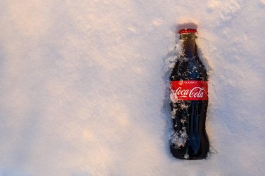 Kazan, Rusya, Mart, 17, 2018: Özgün cam şişe Coca-Cola donmuş karda parlak gün batımı sıkışmış