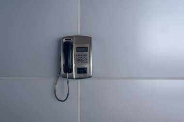 Retro ankesörlü telefon Metro gri duvar.