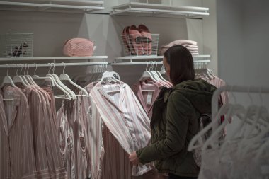 Genç kadın evde pijama, ev giyim mağazası, trendy pastel renkler seçer