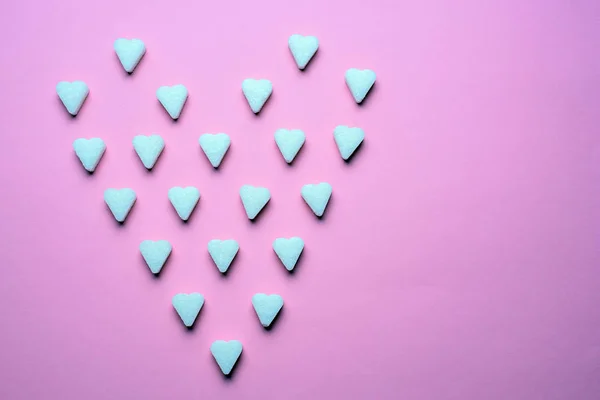 Hintergrund aus raffiniertem Zucker in Herzform auf rosa Hintergrund, romantisches Muster — Stockfoto