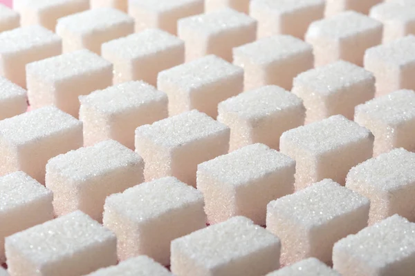 Cubes of refined white sugar the correct geometric shape on a pink background. Minimalistic abstract screensaver — Stock Photo, Image