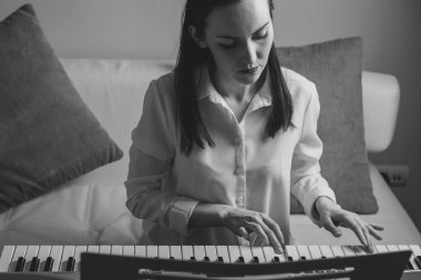 Siyah beyaz portre elektronik piyano çalmayı öğrenme genç bir kadın
