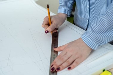 Bir kalem ve bir cetvel ile el close-up bir mimari proje çizmek