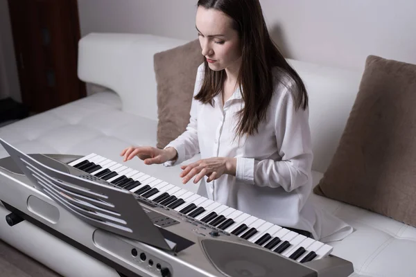 Portrait from the top of the woman playing the piano in the room of the apartment — Stock Photo, Image