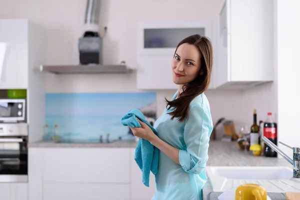 Retrato del lado de una joven morena con una toalla en las manos en el interior de una cocina luminosa — Foto de Stock