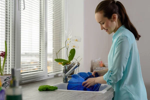 Lavavajillas. Mujer joven con placa azul en frente de la ventana de la cocina — Foto de Stock