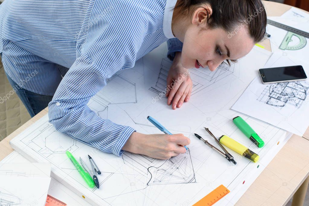 Woman the designer draws architectural design using a pencil