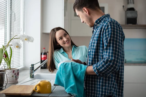 Couple washing dishes together after dinner, a happy family life — Stock Photo, Image