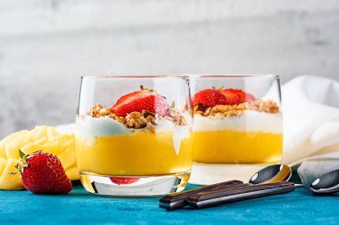 iki bardak meyve ve çilekli mango ve çilekli granola ve vanilyalı krema veya ricotta