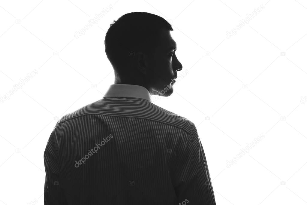 silhouette of a European man from behind in a business shirt looks towards the isolate on white