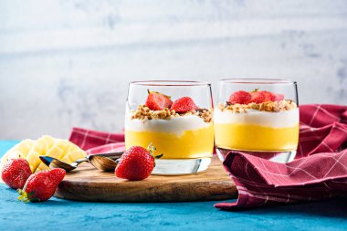 iki bardak meyve ve çilekli mango ve çilekli granola ve vanilyalı krema veya ricotta
