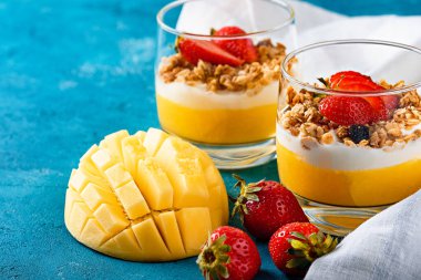 iki bardak meyve ve çilekli mango ve çilekli granola ve vanilyalı krema veya ricotta