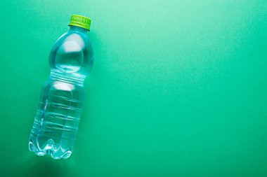 yeşil küçük plastik temiz su şişesi. Nane arkaplanda kopyalama alanı var.
