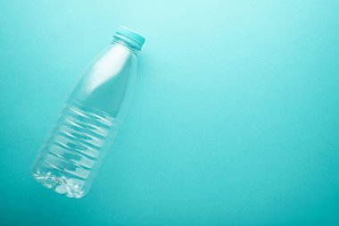 Turkuazın üzerinde mavi kapaklı limon Plastik şişe, kopyalama alanı olan neo naneli arkaplan