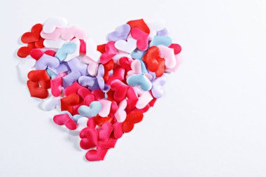 Beyaz arkaplanda çok renkli küçük kalpler