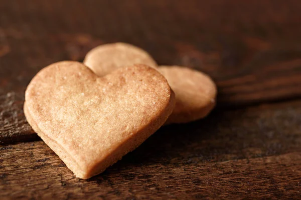 Galletas caseras en forma de corazón sobre fondo de madera marrón — Foto de Stock