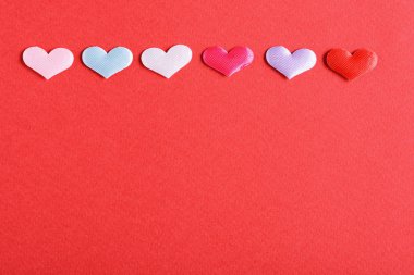 kırmızı bir arka plan üzerinde renkli Kalpler