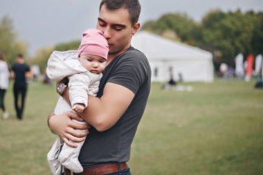 Baba kucağında bebekle Park 'ta başını öpüyor.