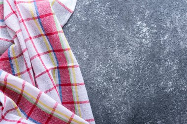 Üst manzara koyu gri arka plan ve mutfak kareli havlu.