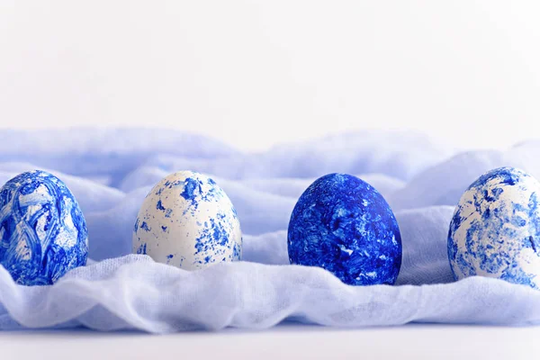 Easter eggs in row of white and classic blue on soft blue towel on white background — 스톡 사진