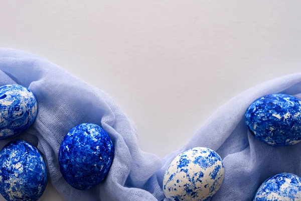 Paaseieren in de kleur van het jaar-klassiek blauw met verloop effect op zacht blauwe loth servet op witte achtergrond — Stockfoto