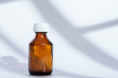 Beyaz arka planda boş kahverengi cam tıbbi şişe