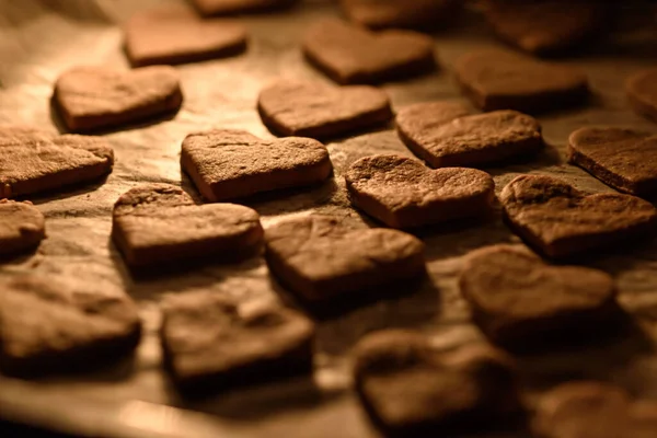 Biscuits de cuisson coeurs sur papier sulfurisé dans le four — Photo