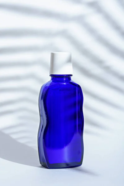 Classic blue glass cosmetic bottle on white background — 스톡 사진