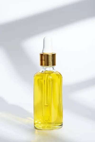 하얀 배경에 화장품용 노란색 기름을 바른 피펫 이 있는 유리병 — 스톡 사진