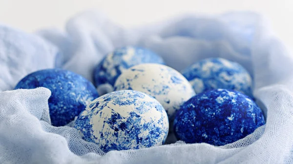 Classic blue eggs with gradient effect in textile nest for Easter on white background — 스톡 사진