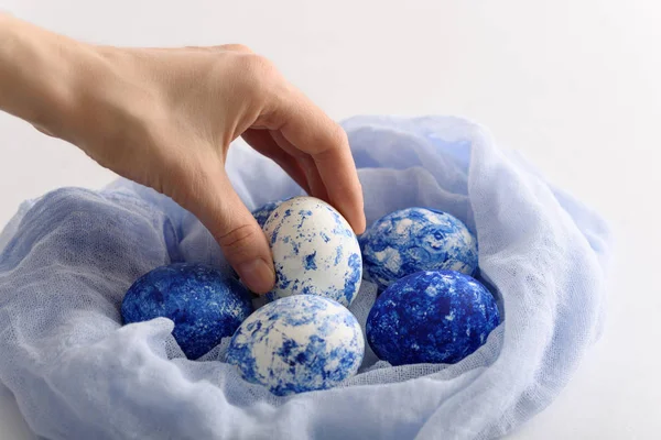 Closeup classic blue eggs with gradient effect in textile nest for Easter on white background — 스톡 사진