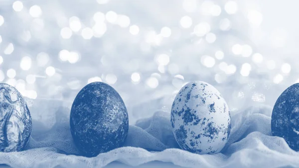 Tinted white Easter eggs with pattern and gradient effect in fabric towel on glowing background — 스톡 사진