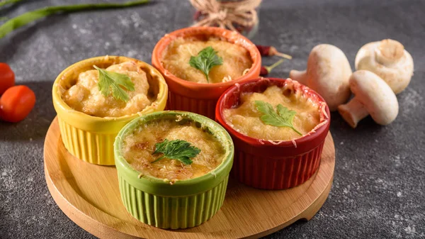 Closeup casserole with cheese in colorful cocoanuts with mushrooms and vegetables on gray background — Stock Image Closeup casserole with cheese in colorful cocoanuts with mushrooms and vegetables on gray background Royalty Free Stock Photos