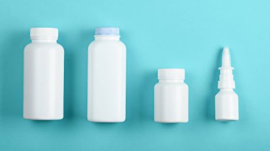 Üst görünüm dört beyaz tıbbi konteynır mavi arka planda şişe maket ve markalaşma için