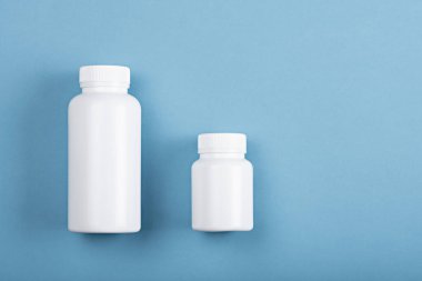 En üstteki görünüm mavi arkaplan üzerinde iki plastik beyaz şişe kopya alanı ile etiketleme