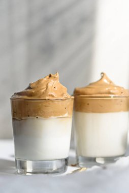 Beyaz arka planda köpük köpüklü düşey dalgona kahvesi, Kore kahvesi konsepti