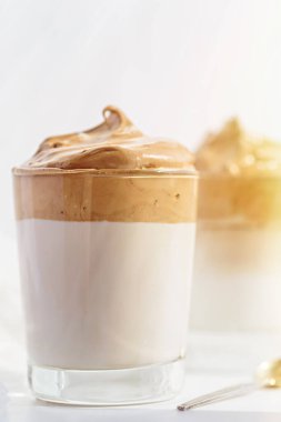 Beyaz arka planda köpüklü köpüklü düşey yakın çekim dalgona kahve, Kore kahvesi konsepti.