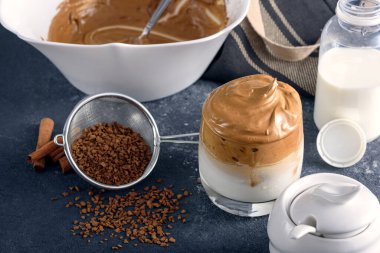 Yakın çekim modası dalgona kahvesi, gri mutfak masasında üretim süreci