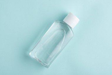 Üst görüş dezenfektanı, mavi arkaplanda antiseptik el jeli, koruma, kopyalama alanı