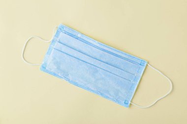 Üst görünüm beyaz arkaplanda tek kullanımlık tıbbi maske