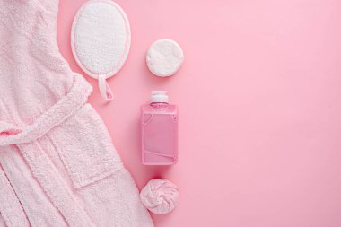 Spa günü, duş aksesuarları, bornoz, jöle, bez, sünger, pembe arka planda sabun, dinlenme ve rahatlama, üst görünümü kopyala
