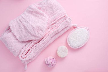 Moda bir banyo ve spa günü, pembe bornoz, el bezi, el yapımı sabun, pembe arka planda tuz, üst manzara, düz yatış