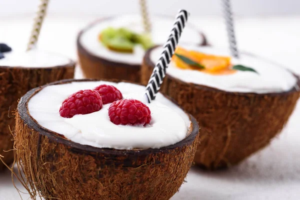 特写镜头奶昔 在椰子碗里放上浆果和管子 背景为白色 冰淇淋 流行的食物概念 — 图库照片