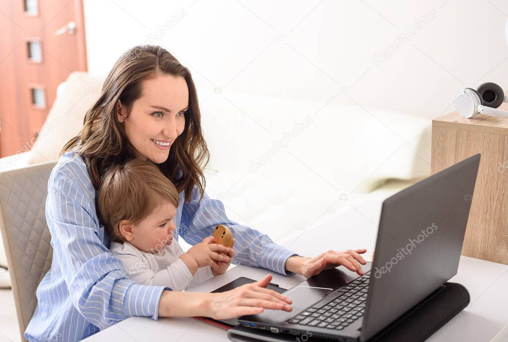 happy mother and daughter sitting at laptop, remote work at home, motherhood, maternity leave, online interactive learning