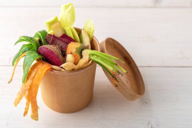 Gübreleme konsepti, karton içinde sebze kabukları beyaz arka planda biyolojik olarak çözünebilir konteynır, yiyecek atıkları