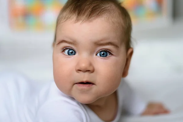 Gros Plan Bebe Aux Yeux Bleus En Body Blanc Sur Lit Blanc Heureux Adorable Stock Photo