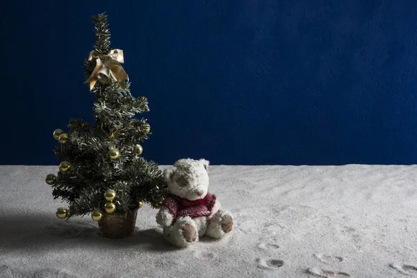 Beyaz kumları ve mavi arka plan üzerinde Noel oyuncaklar